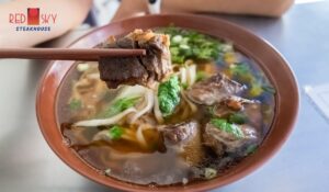 Fresh Danang Fish Cake Noodle Soup with herbs and lime – famous Central Vietnam specialty.